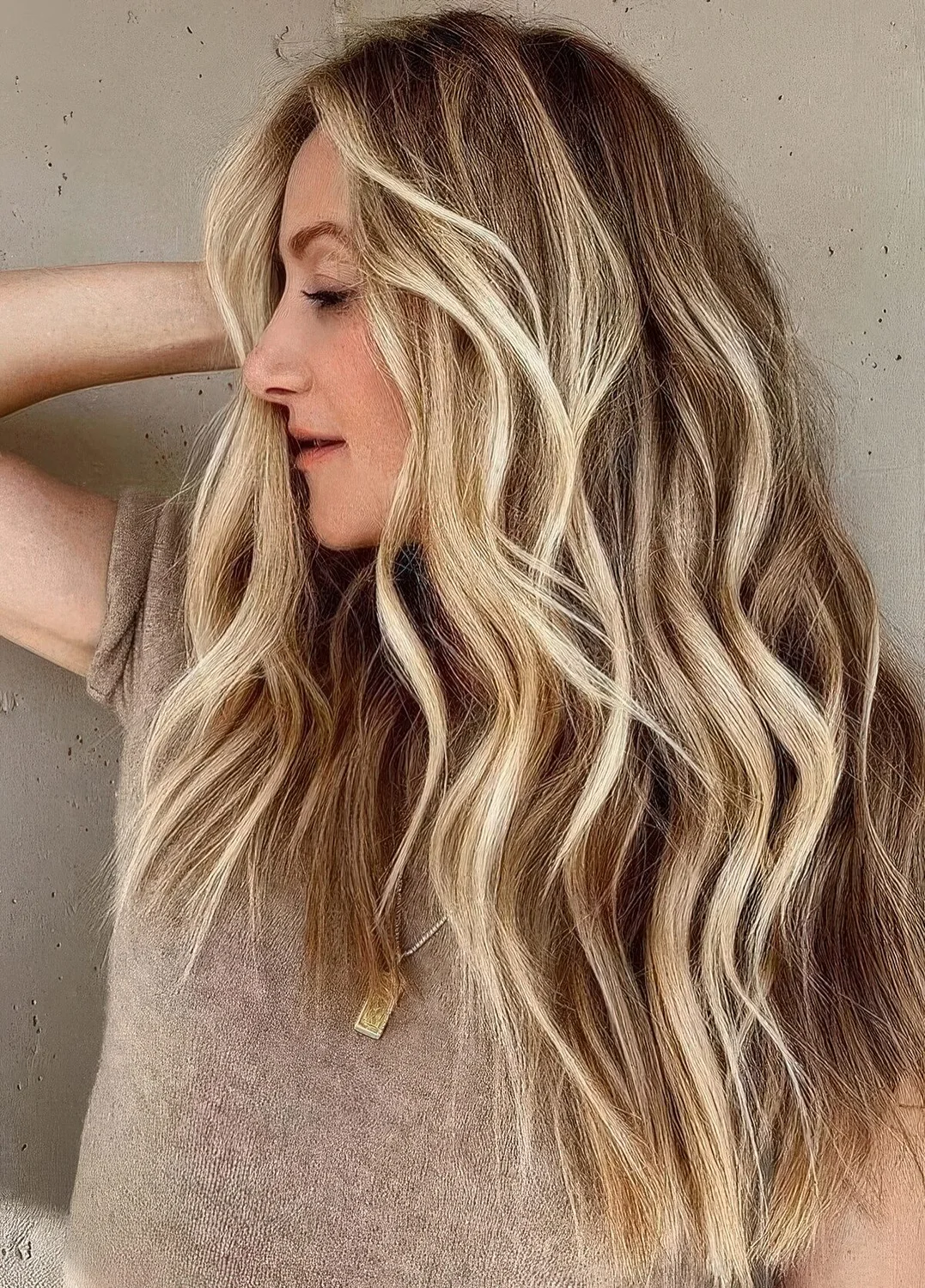 Dimensional beach blonde balayage on bronde hair and beach waves.