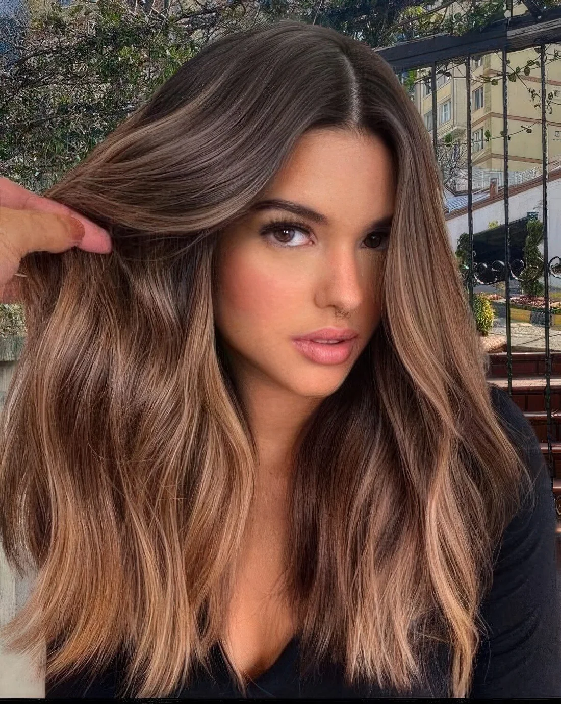Long and wavy dark hair with a volume and super delicate and neutral caramel balayage.