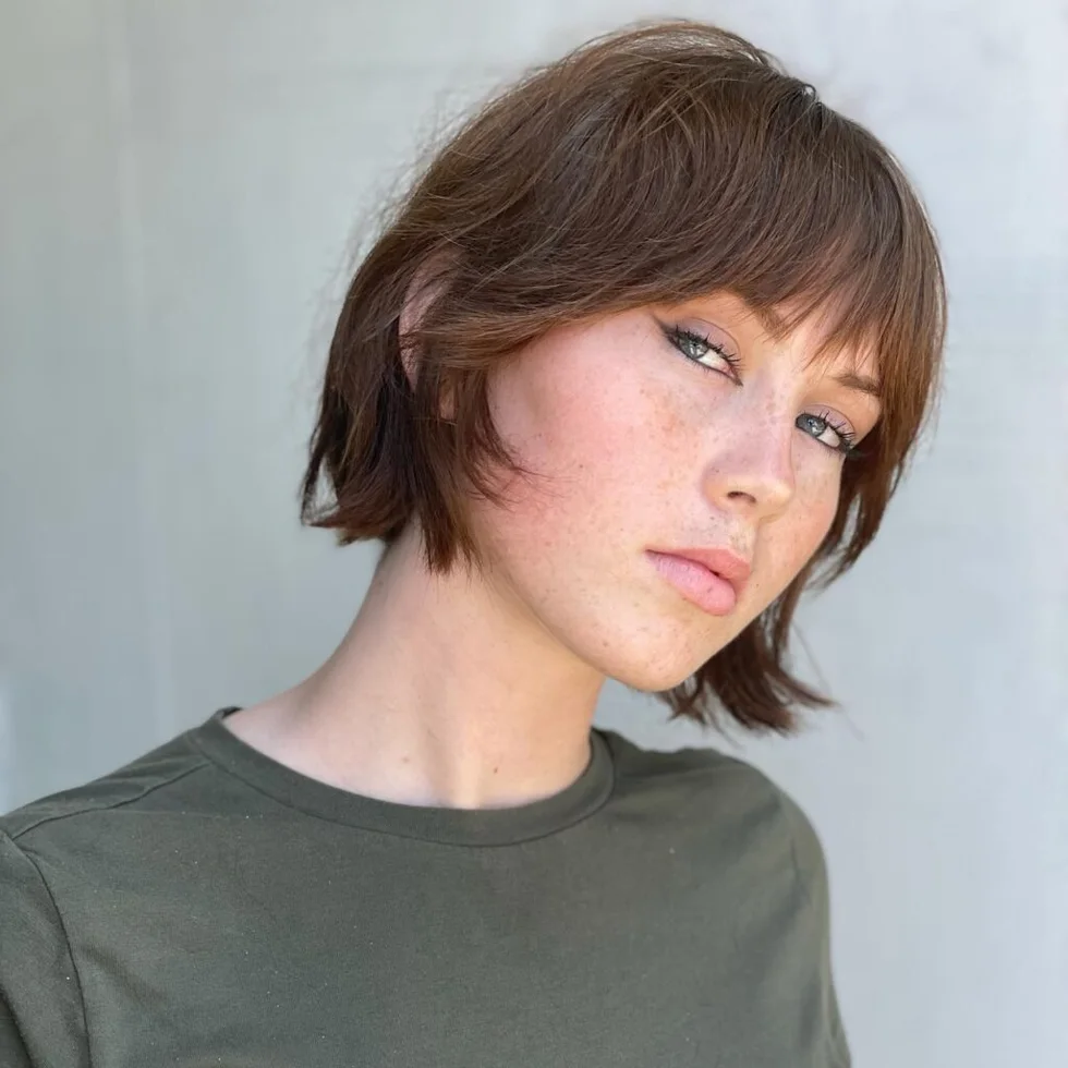 jaw wavy chestnut bob with side swept fringe shown as a low maintenance haircuts for fine hair idea