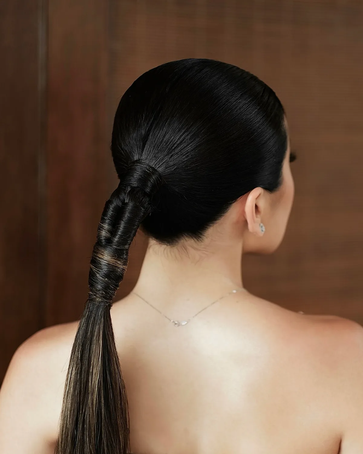 chest straight black ponytail shown as a low ponytail hairstyles idea, featuring glossy finish, shown in slick wrapped low ponytail