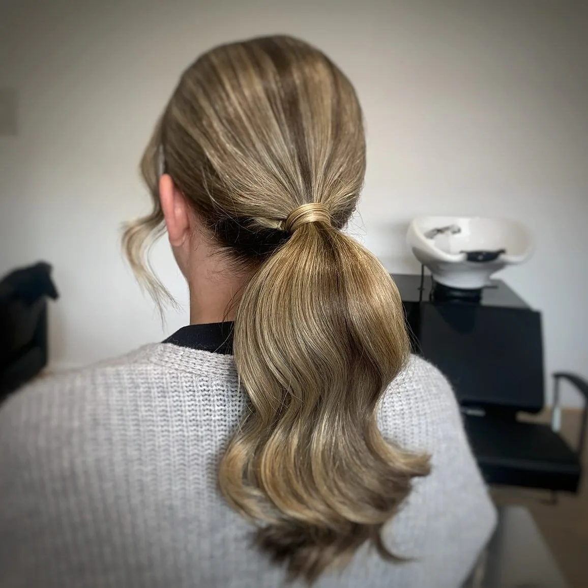 chest wavy blonde ponytail shown as a low ponytail hairstyles idea, featuring blonde color, shown in blonde voluminous low ponytail