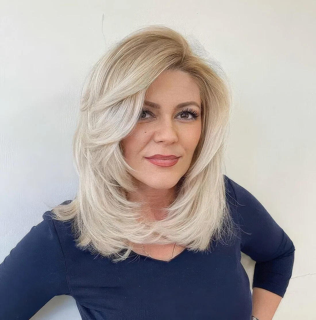 Bleached blonde medium-length butterfly haircut with a lot of volume.