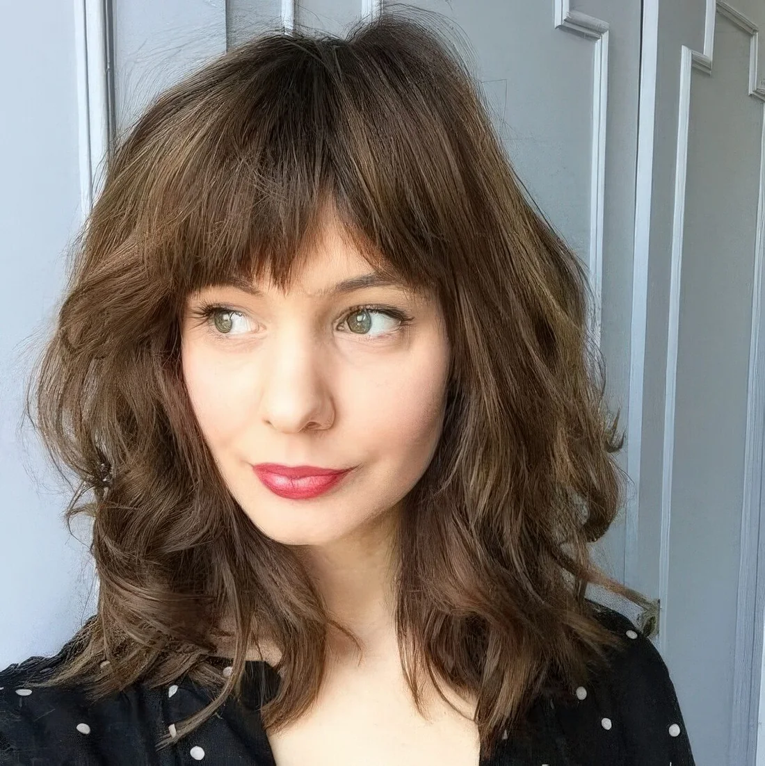 Photo showing medium wavy haircut, with the hairstyle clearly visible.