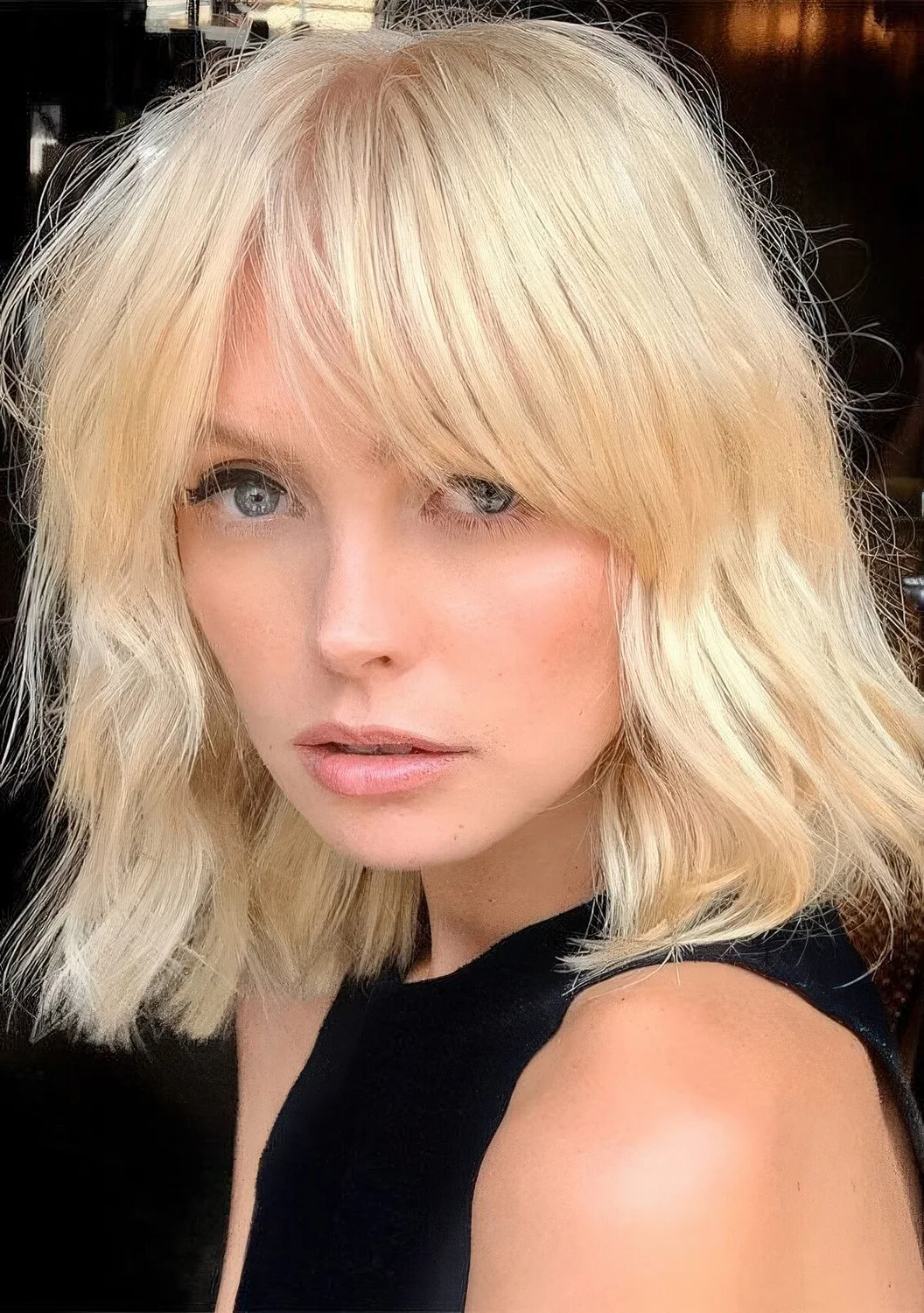 Blonde medium-length haircut with bottleneck bangs and a bit of texture.