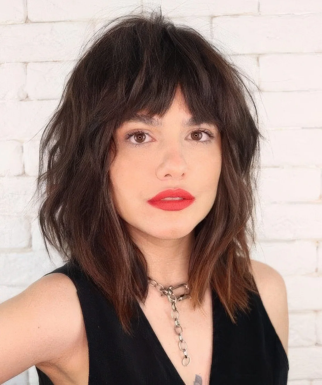 Choppy and shaggy rich brown layered haircut with bottleneck bangs and messy texture.