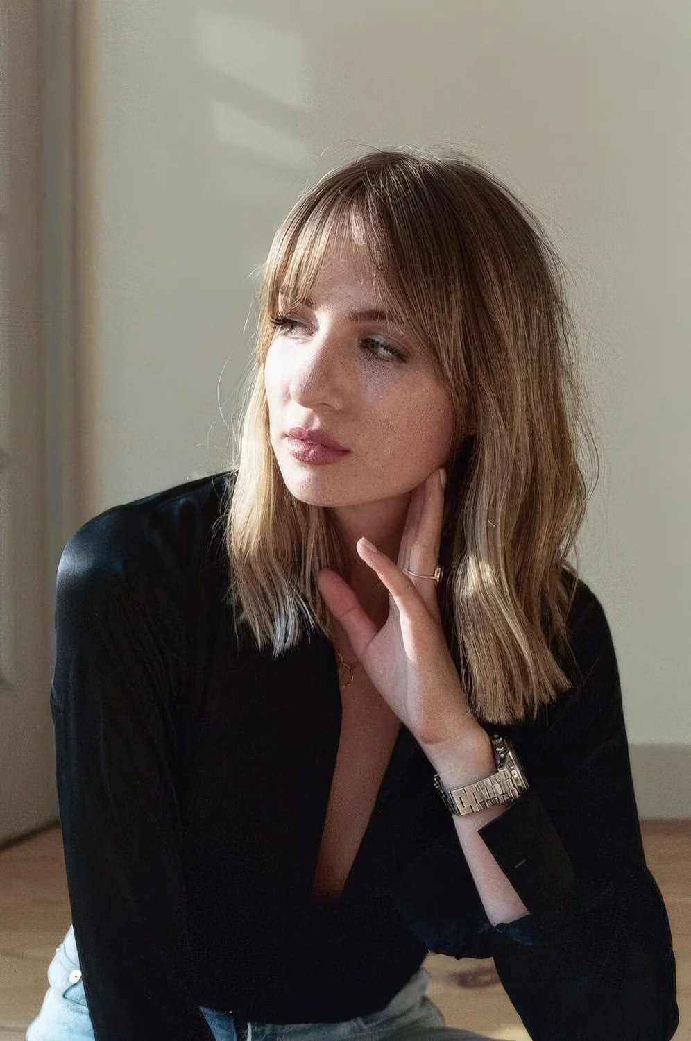 Medium-length blonde haircut with bottleneck bangs.