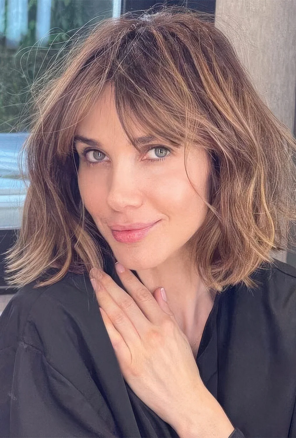 Medium-length caramel haircut with bottleneck bangs and messy waves.