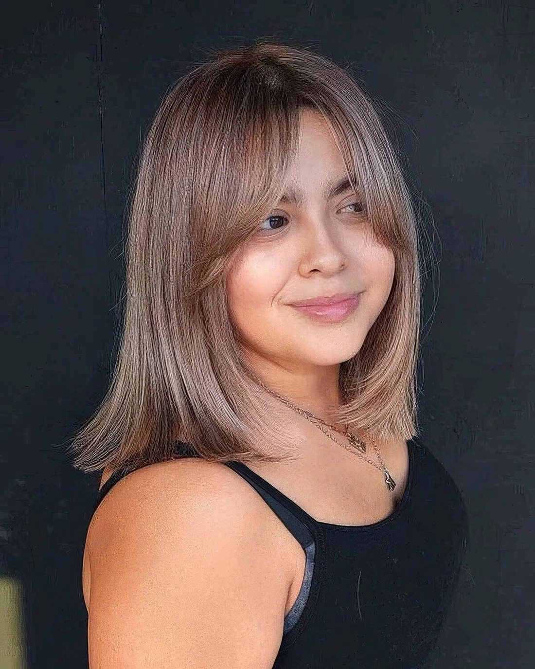 Light brunette shoulder-length hair with bottleneck bangs and a sleek texture.