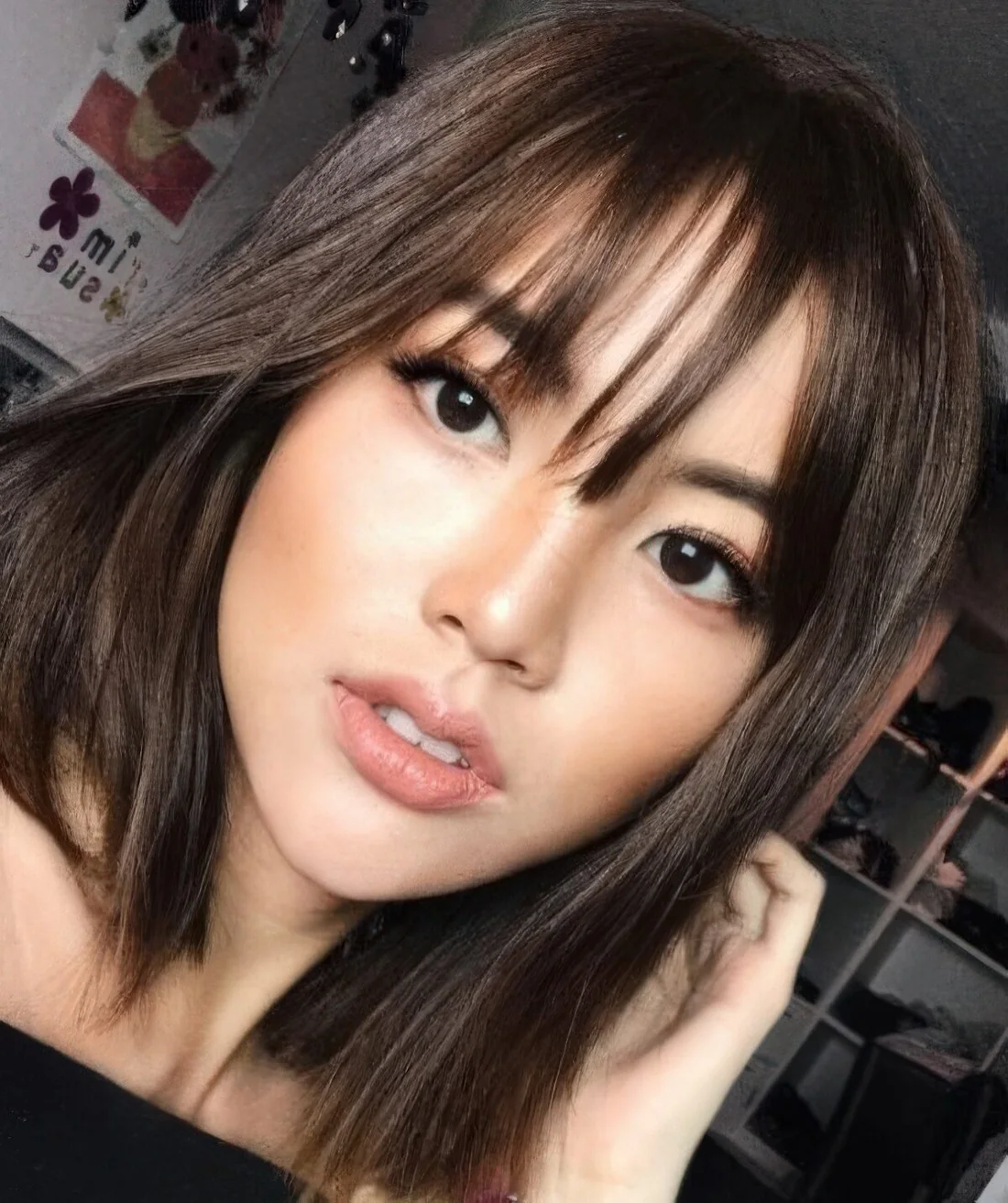 Shiny dark chestnut medium-length hair with wispy bangs.