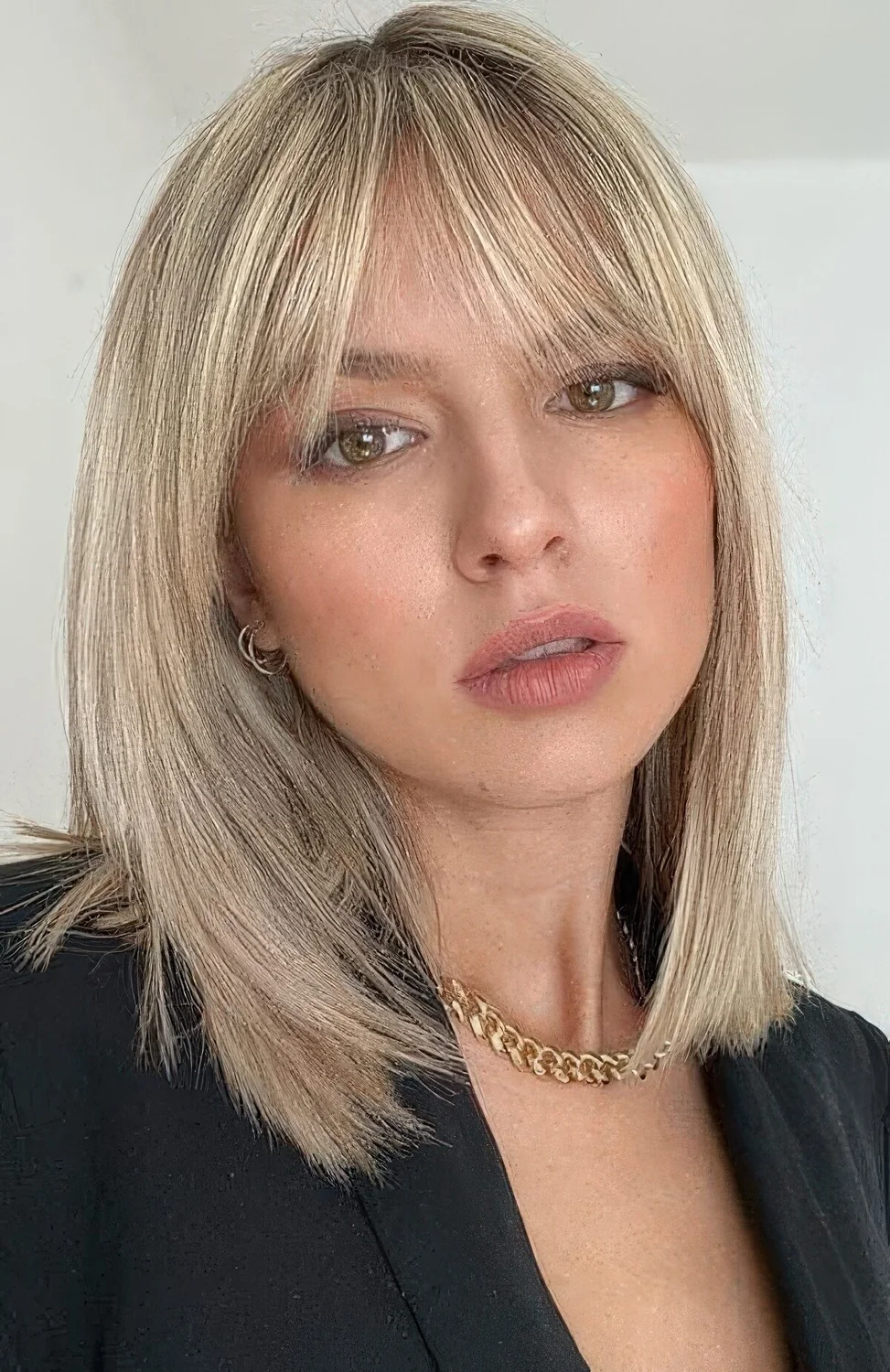 Medium-length blonde hair with wispy bangs.