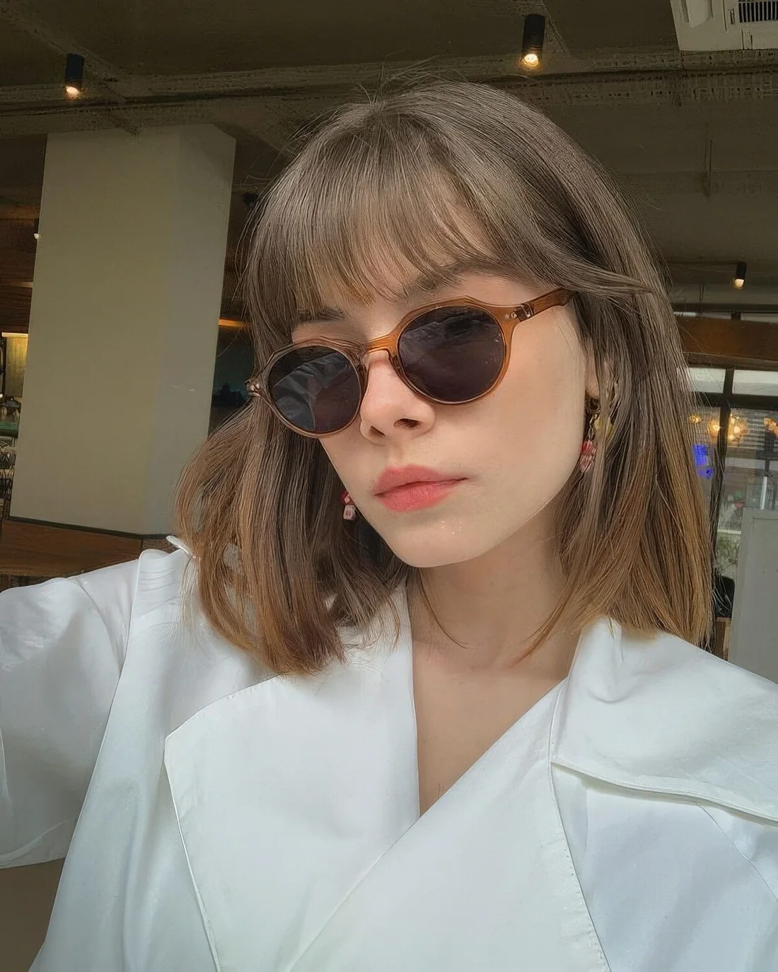 Medium-length brunette hair with wispy bangs to accent the eyes and take off excessive weight off the face.