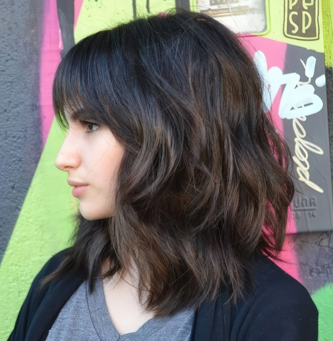 Medium-length haircut with bangs and much dimension.