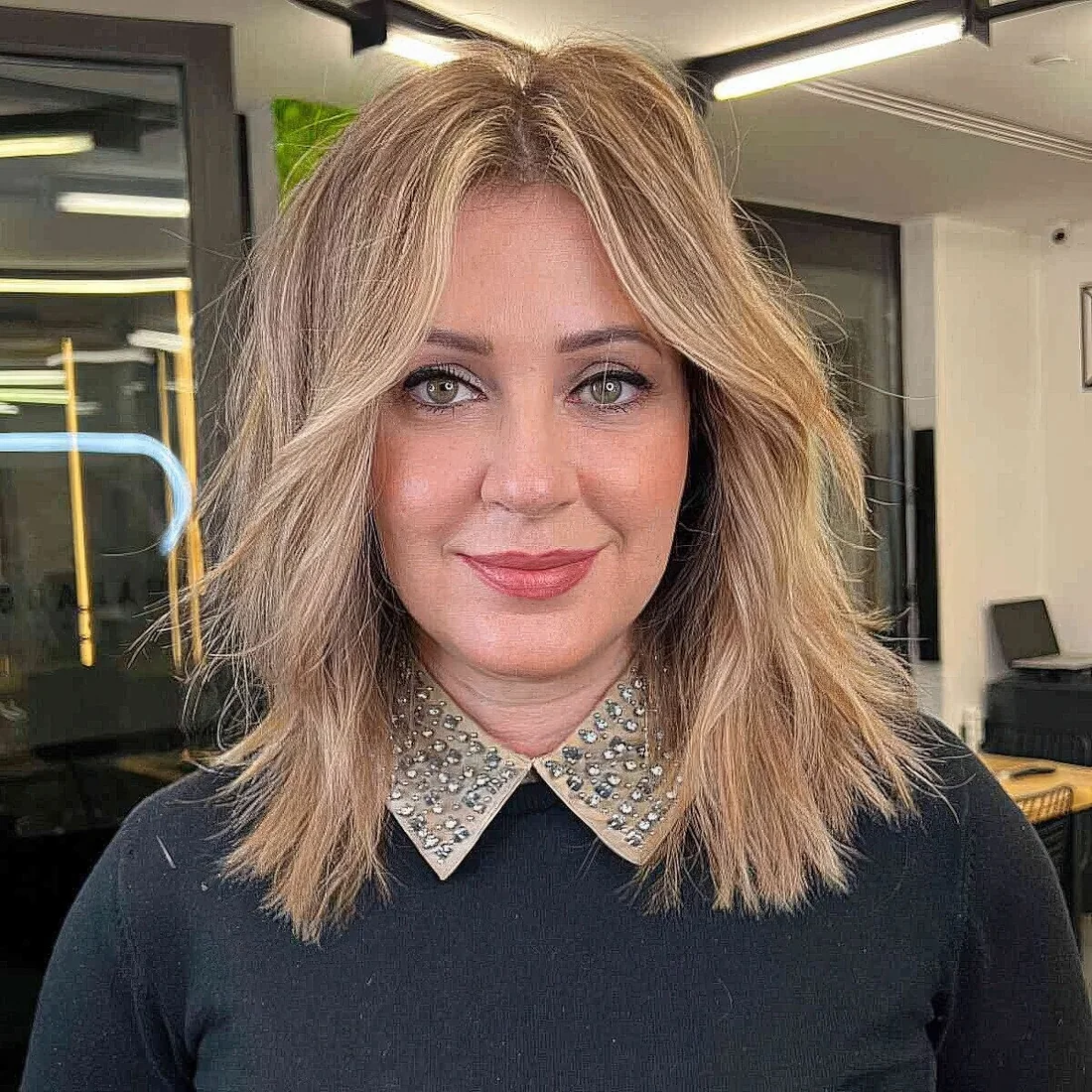 Choppy haircut with balayage, soft curtain bangs for an effortless look without any bulky movement.