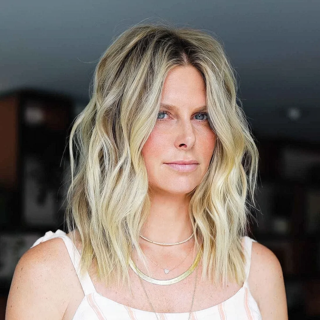Medium layered and choppy haircut in blonde, with darker root and layers.