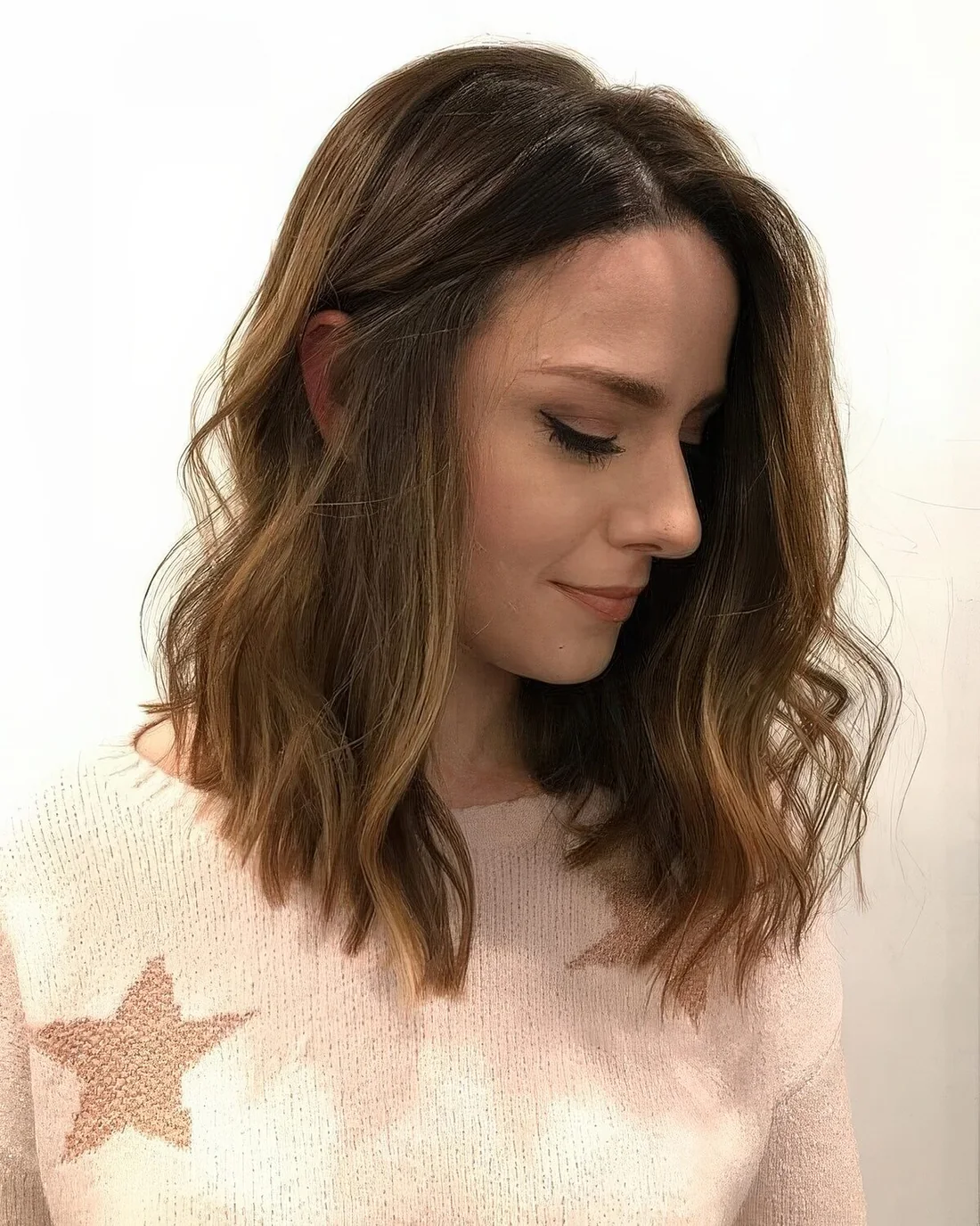 Soft brown medium-length haircut with caramel balayage and waves.
