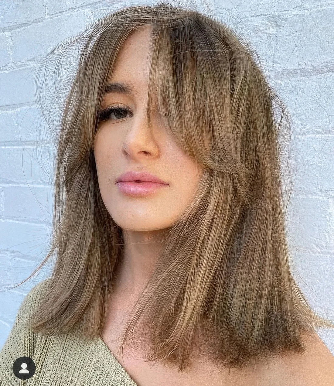 Bronde medium-length hairstyle with curtain bangs, messy volume and straight hair.