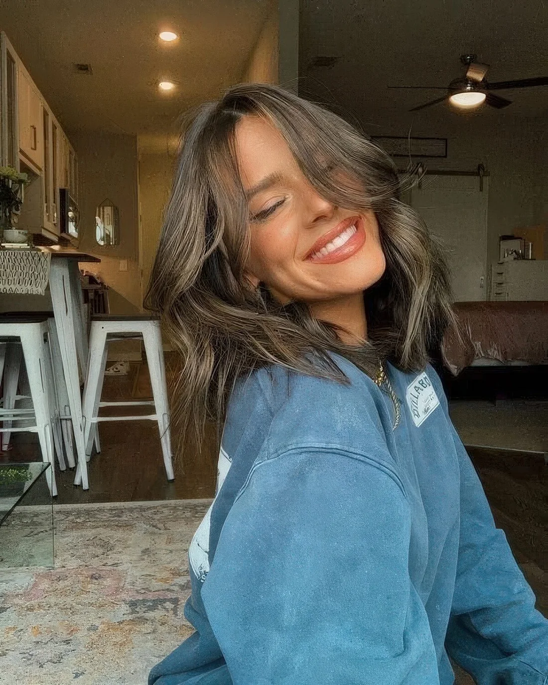 Brunette medium-length hairstyle with curtain bangs and a bit of texture.