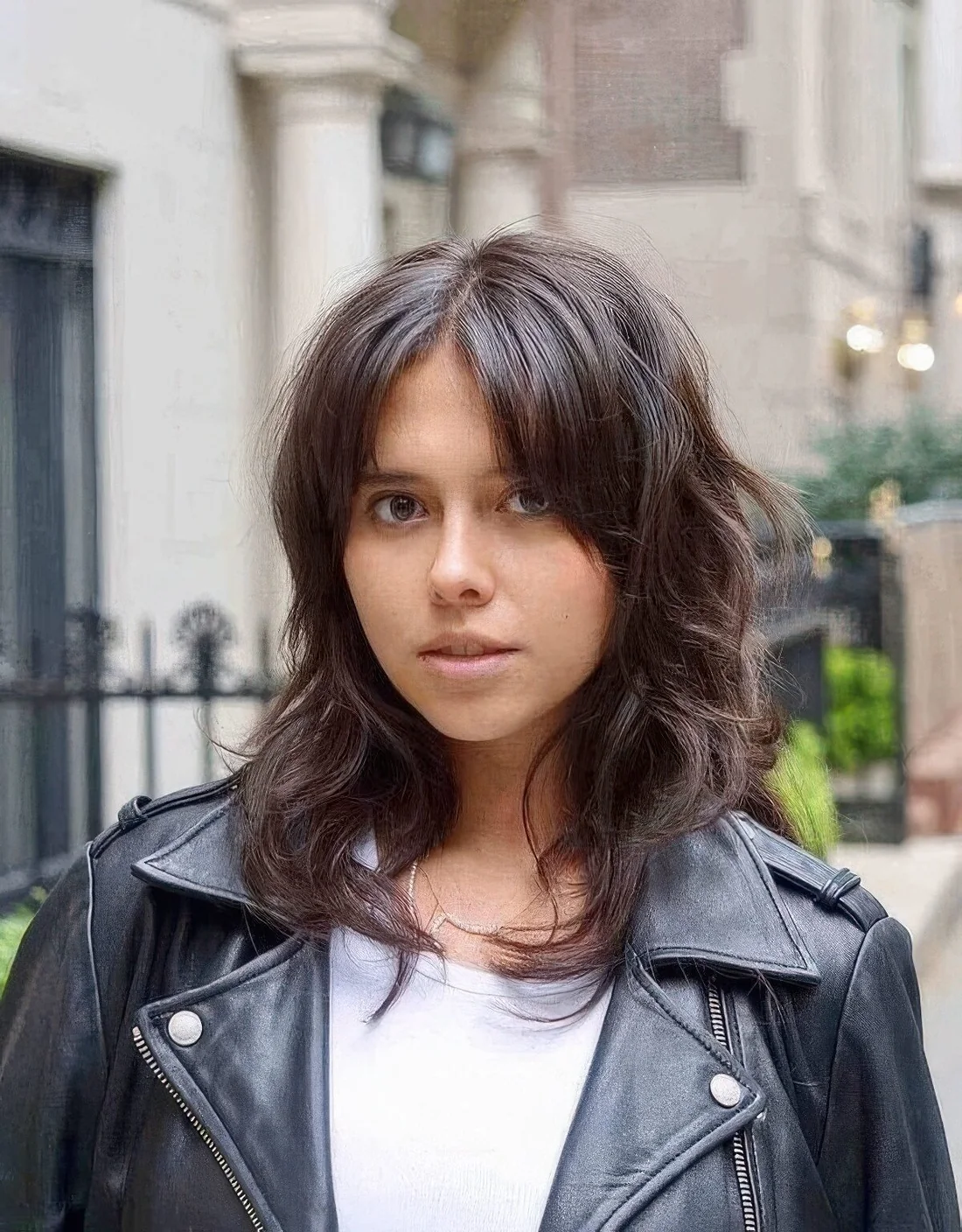 Dark brunette medium wolf cut with curtain bangs and waves.