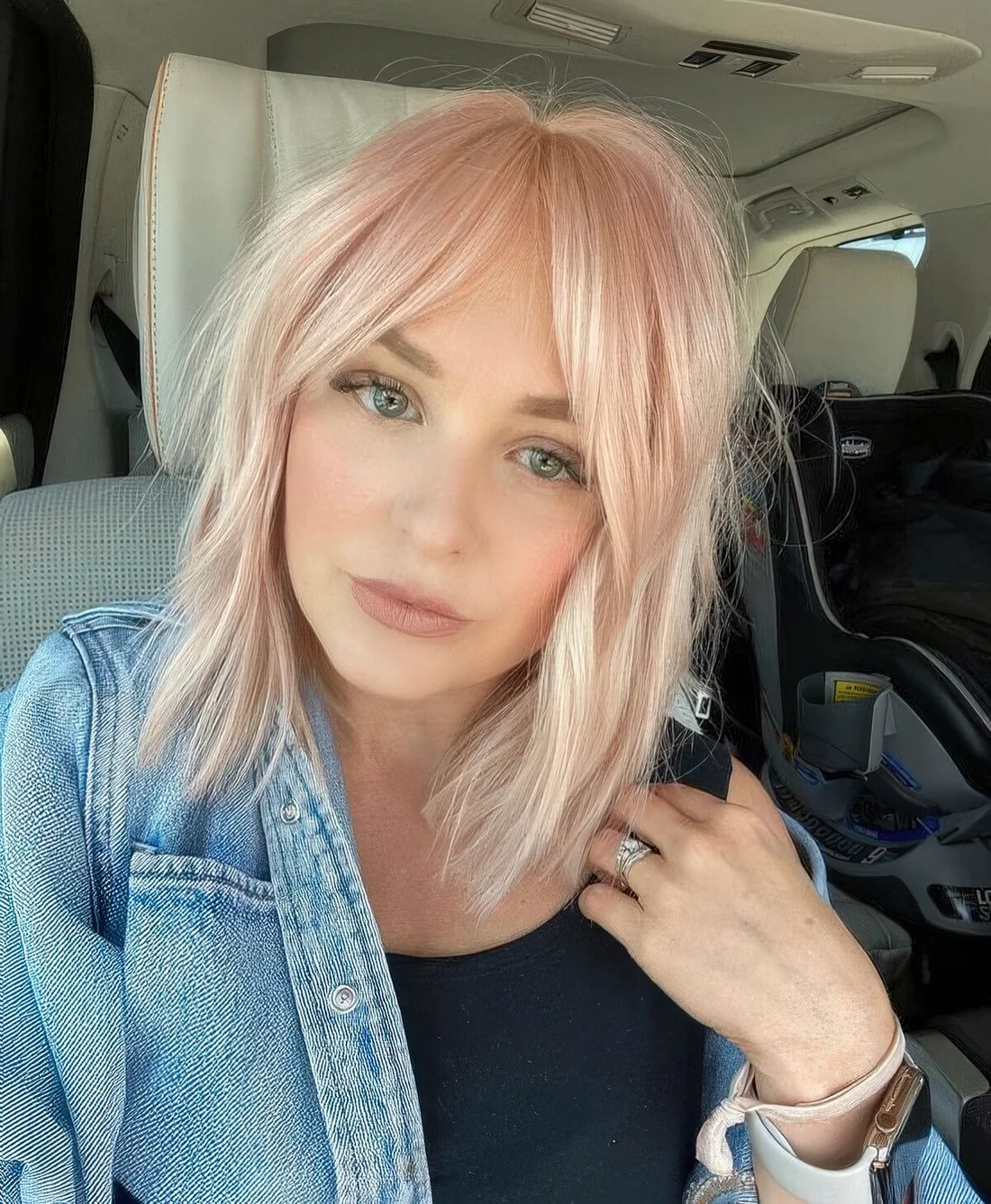 Light pink long bob with curtain bangs and textured hair.