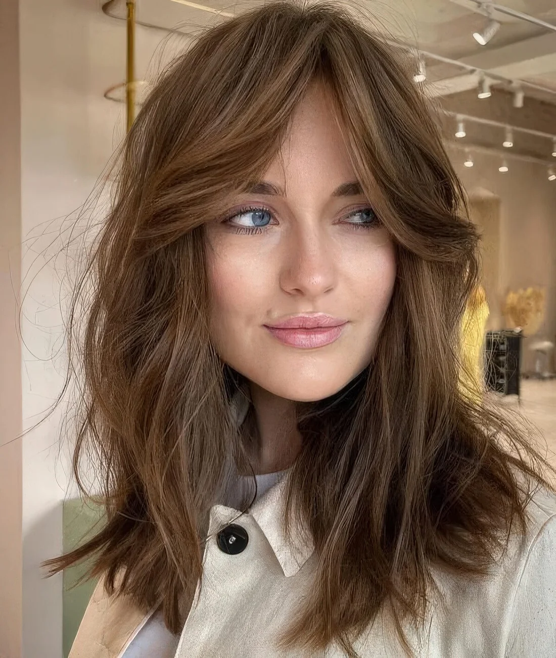 Messy and shaggy medium-length brunette hair with a volume.