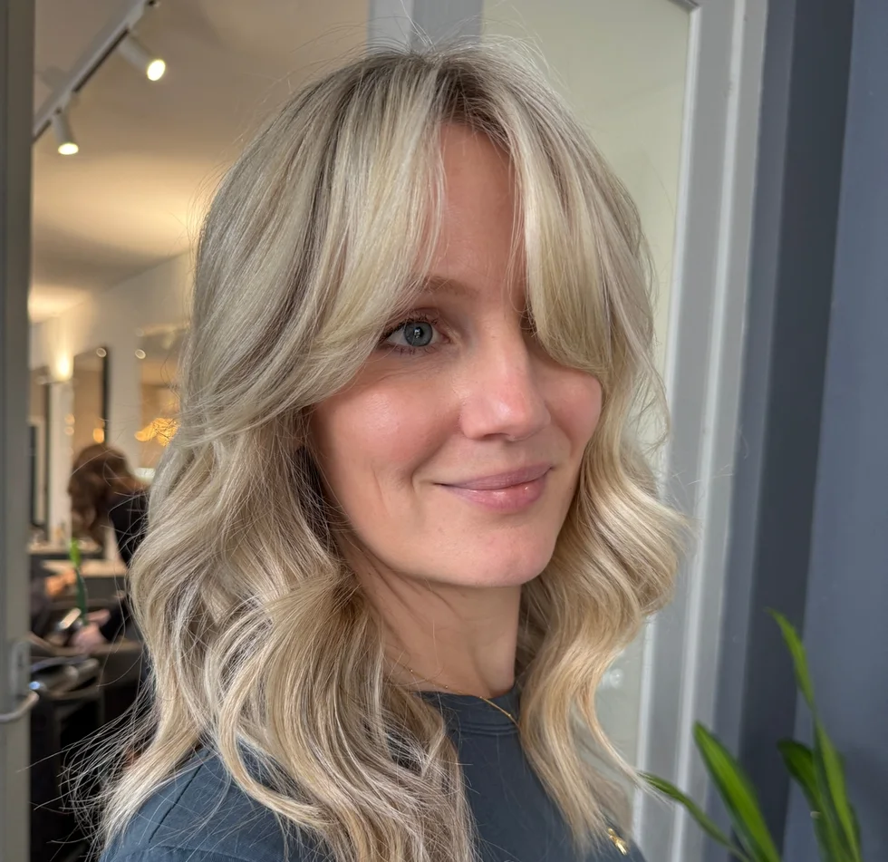 shoulder wavy blonde lob with curtain fringe shown as a medium length haircuts for thick hair idea