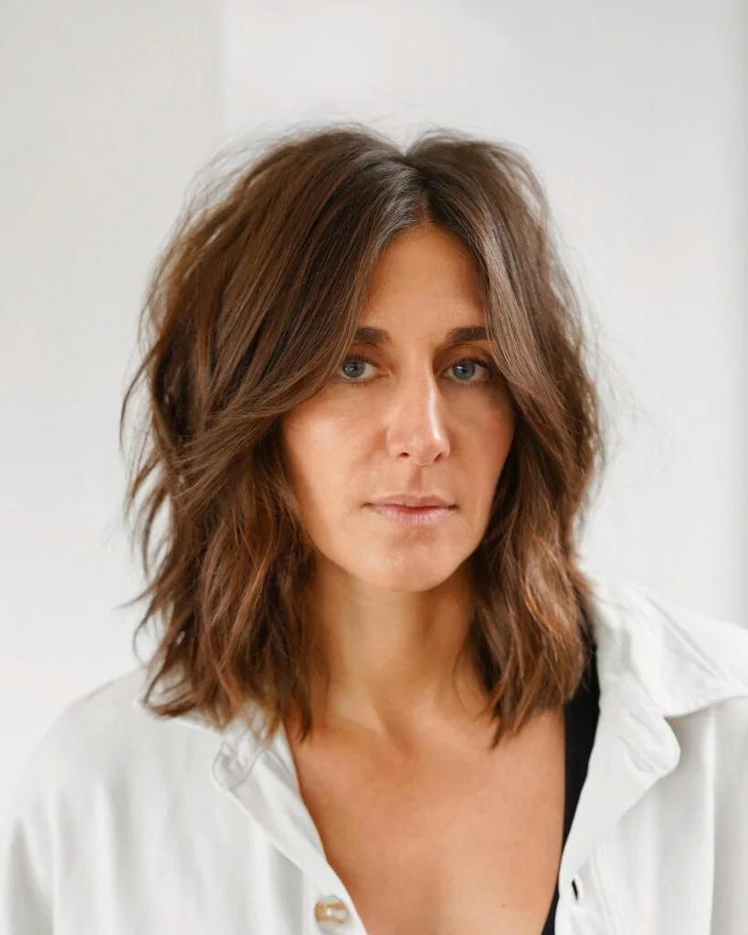 shoulder wavy chestnut shag with curtain fringe shown as a medium length haircuts for thick hair idea, featuring shoulder outline