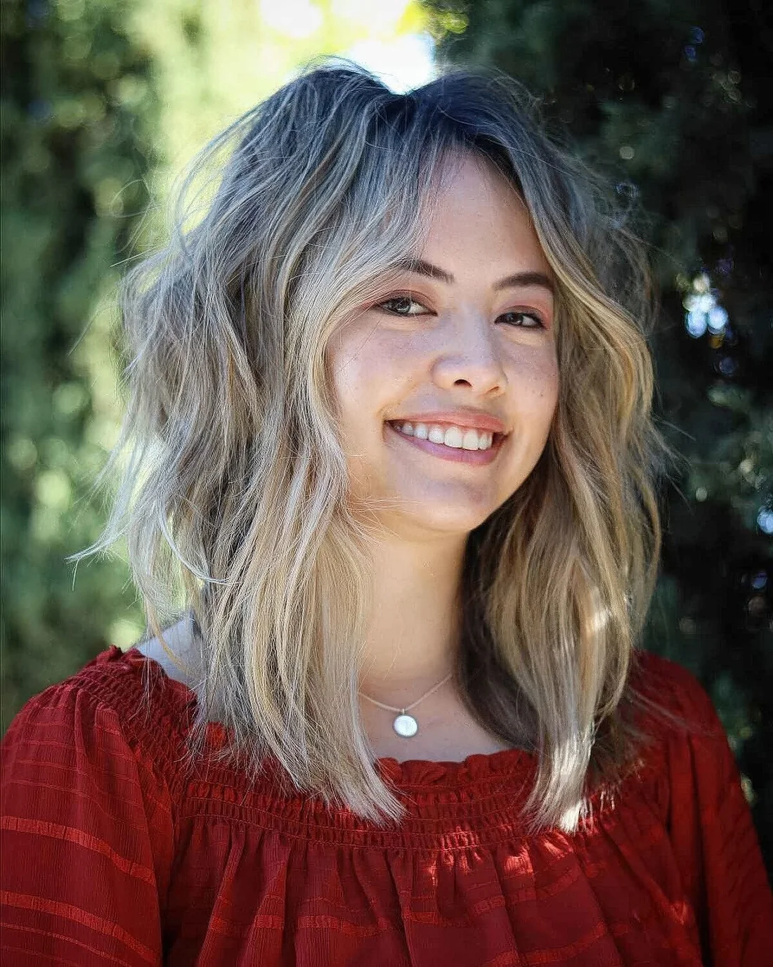 Medium-length shaggy haircut with no bangs or face-framing.
