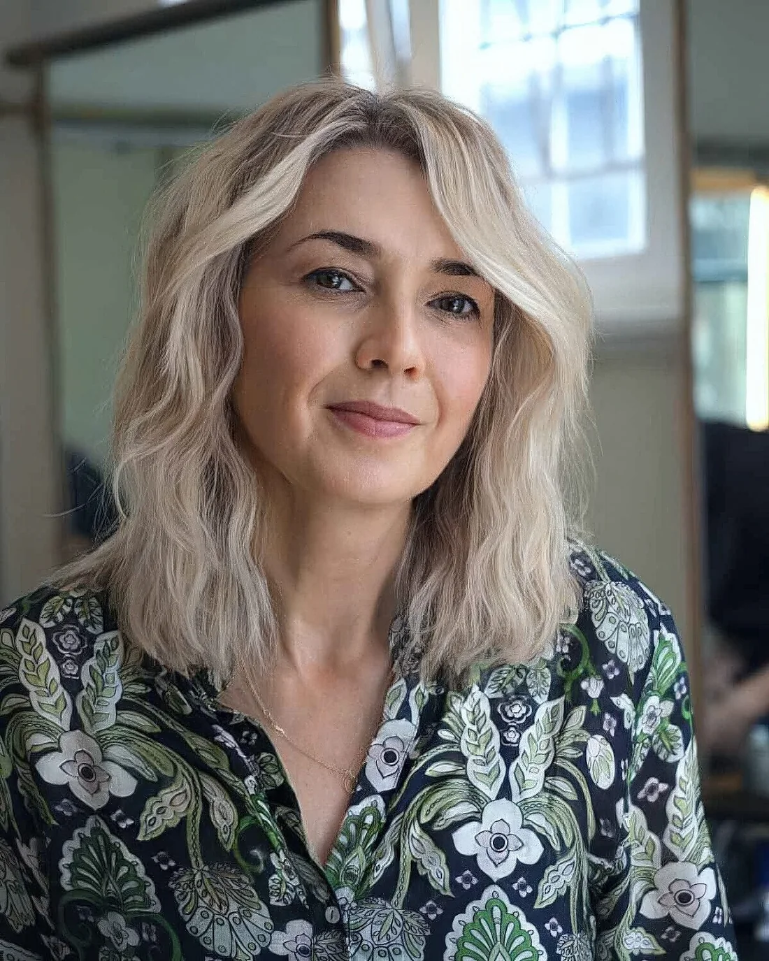 Icy blonde face-framing medium-length haircut.