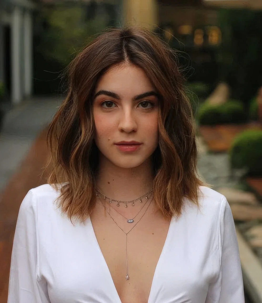 Brunette medium-length hairstyle with caramel balayage and waves.