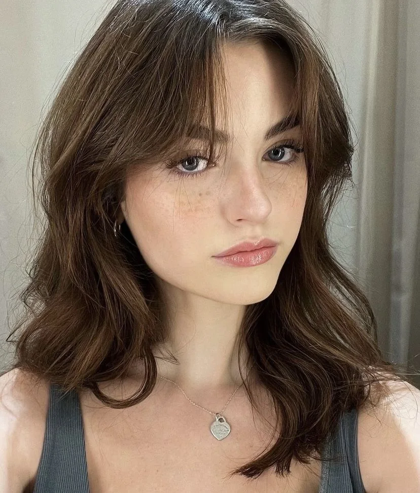 Photo showing layered kitty cut curtain bangs, with the hairstyle clearly visible.