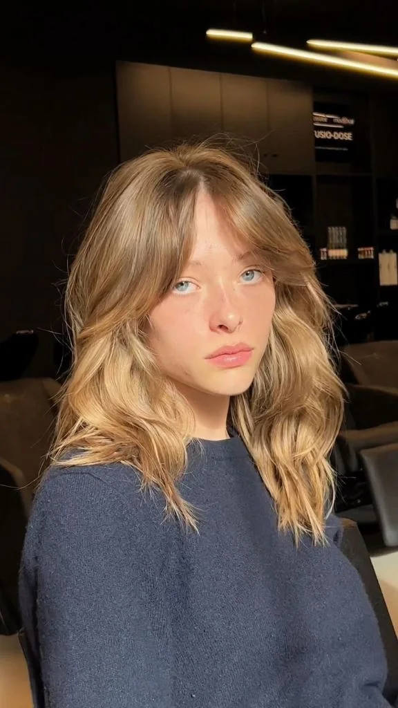 Photo showing layered cut curtain bangs, with the hairstyle clearly visible.