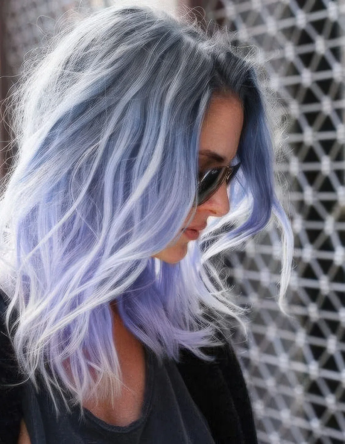 Blue shoulder-length hairstyle with grey root and messy waves.