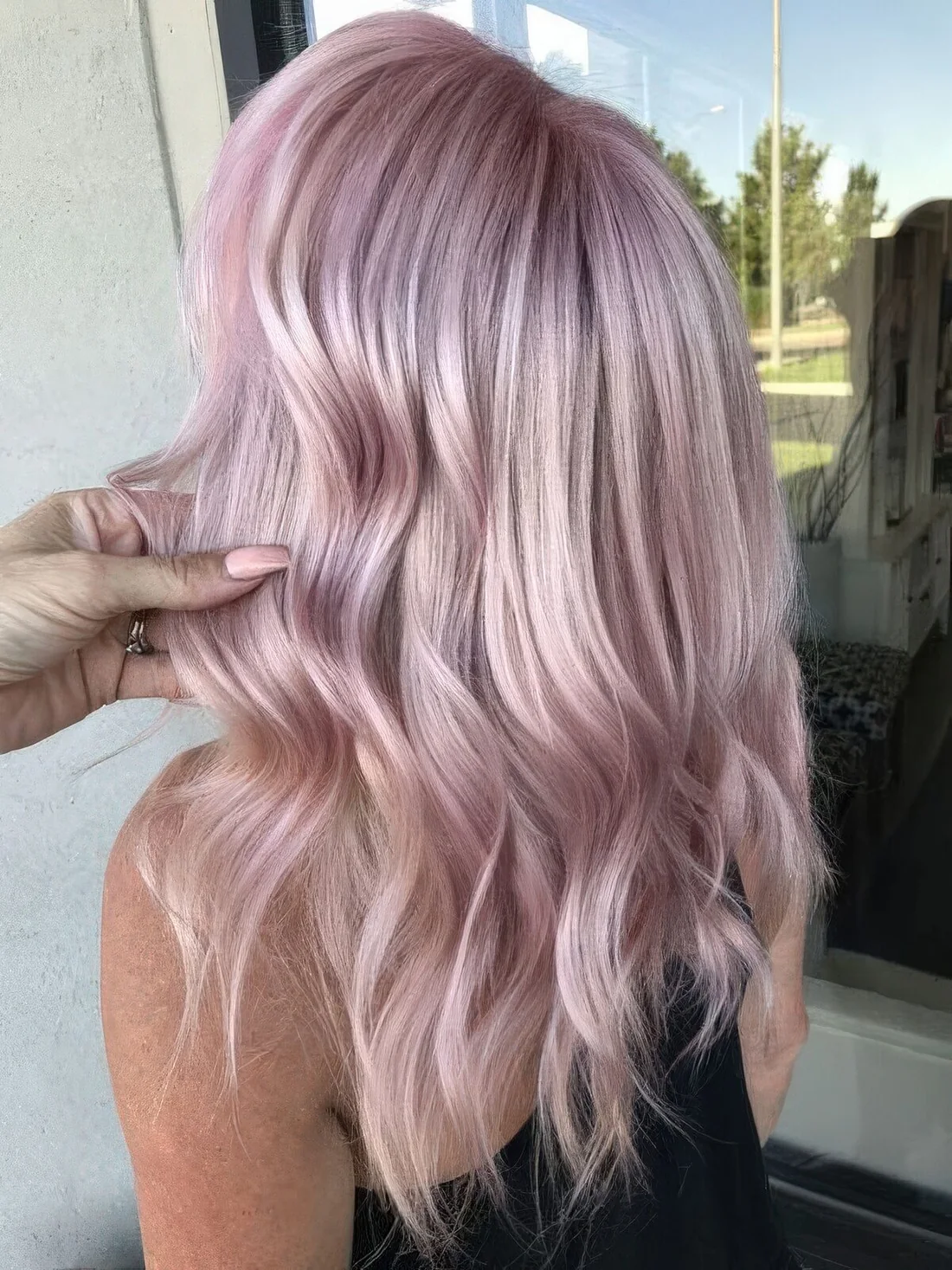 Medium pale pink hairstyle with waves and a bit of volume.