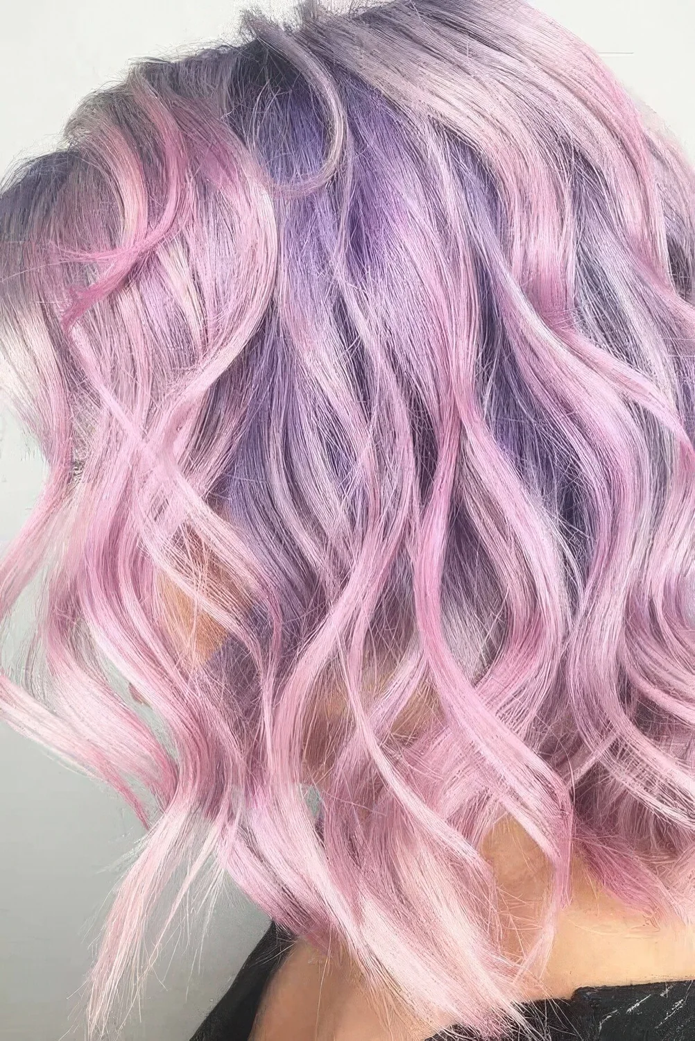 Fab lilac and pink wavy medium-length hair with messy waves.