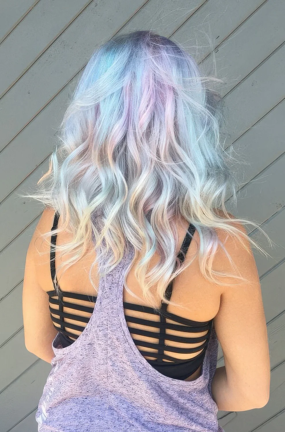 Medium-length mermaid hairstyle with light blue, green and liac and messy waves.