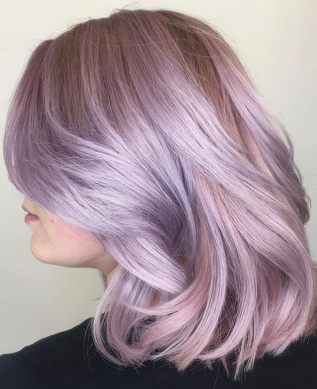 Subtle and chic lilac rose long bob with waves and face-framing layers.