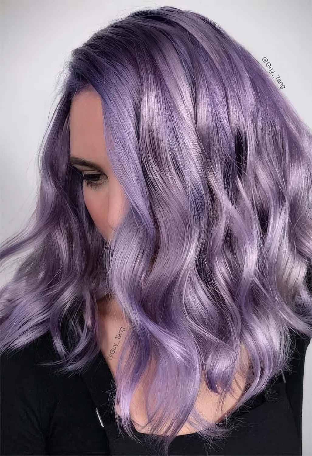 Medium-length purple wavy hair with a lot of volume and side part.