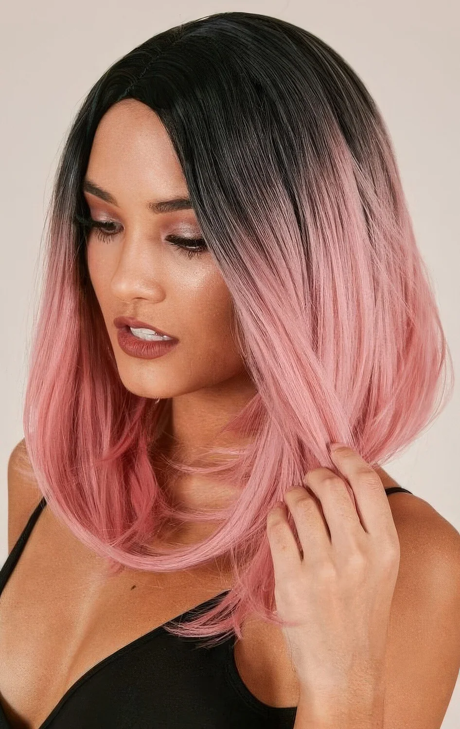 Black roots with pastel pink with an ombre effect on a long bob.