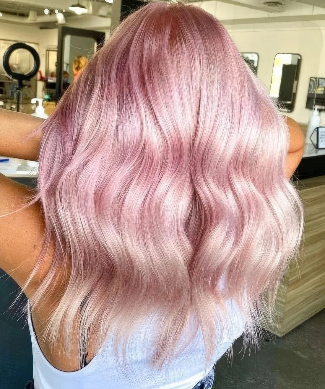 Photo showing peachy rose gold wavy hair, with the hairstyle clearly visible.