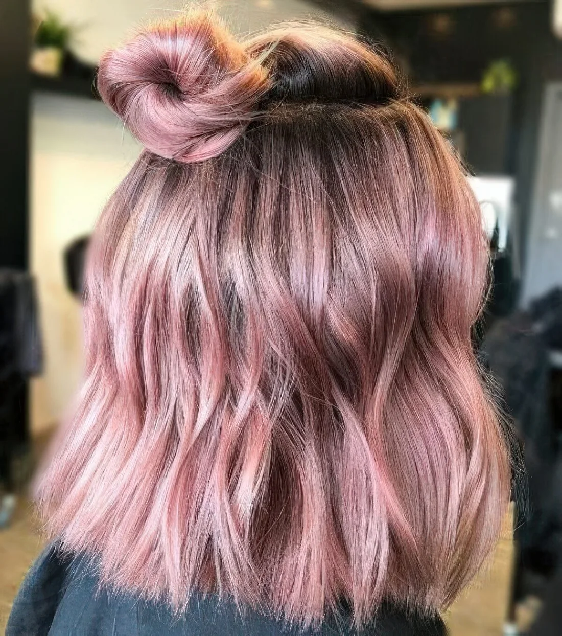 Rose shoulder-length hair with a bit of waves and a top knot.