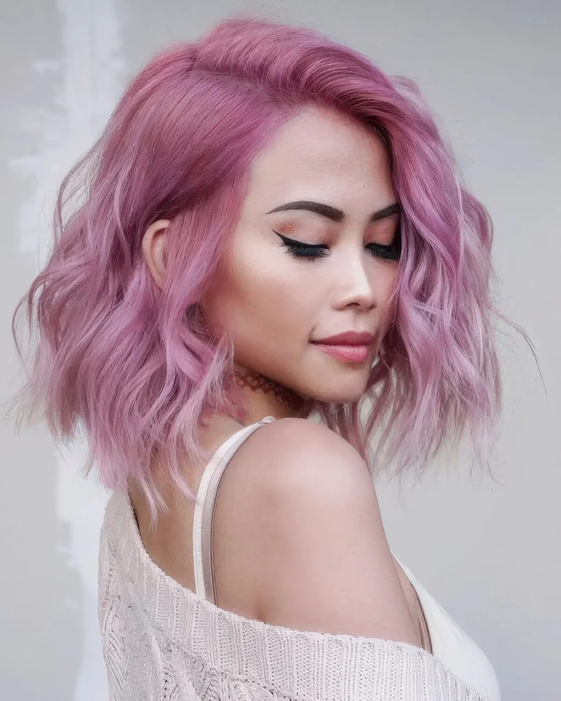 Shoulder-length pink hair with a slight ombre effect and waves.