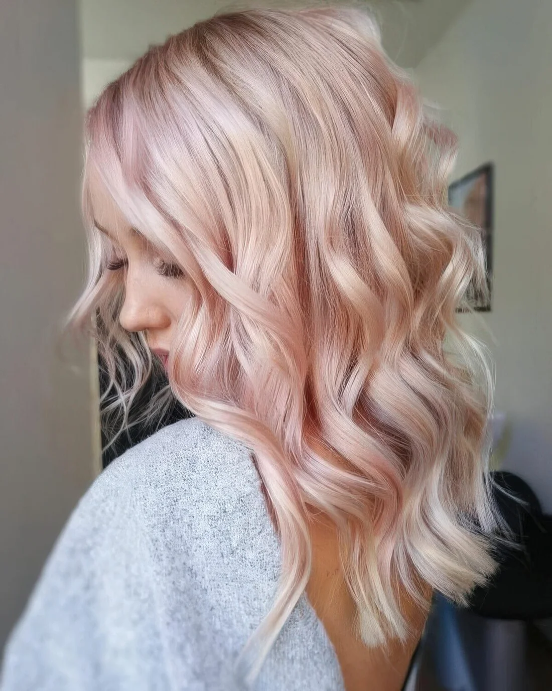 Photo showing long wavy peachy rose blonde hair, with the hairstyle clearly visible.