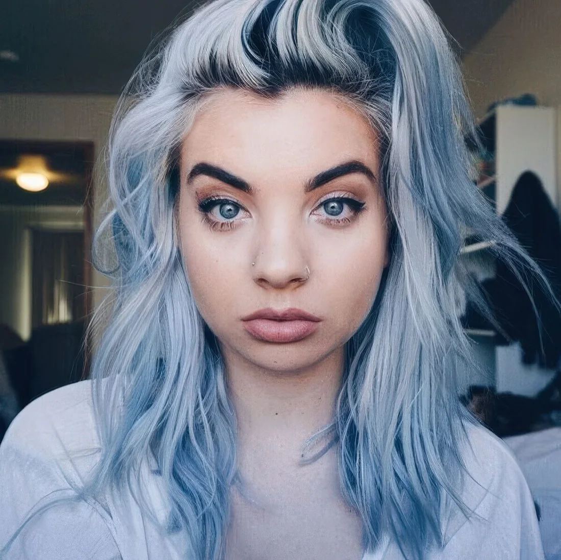 Shaggy and textural medium-length pastel blue hair with a darker root.