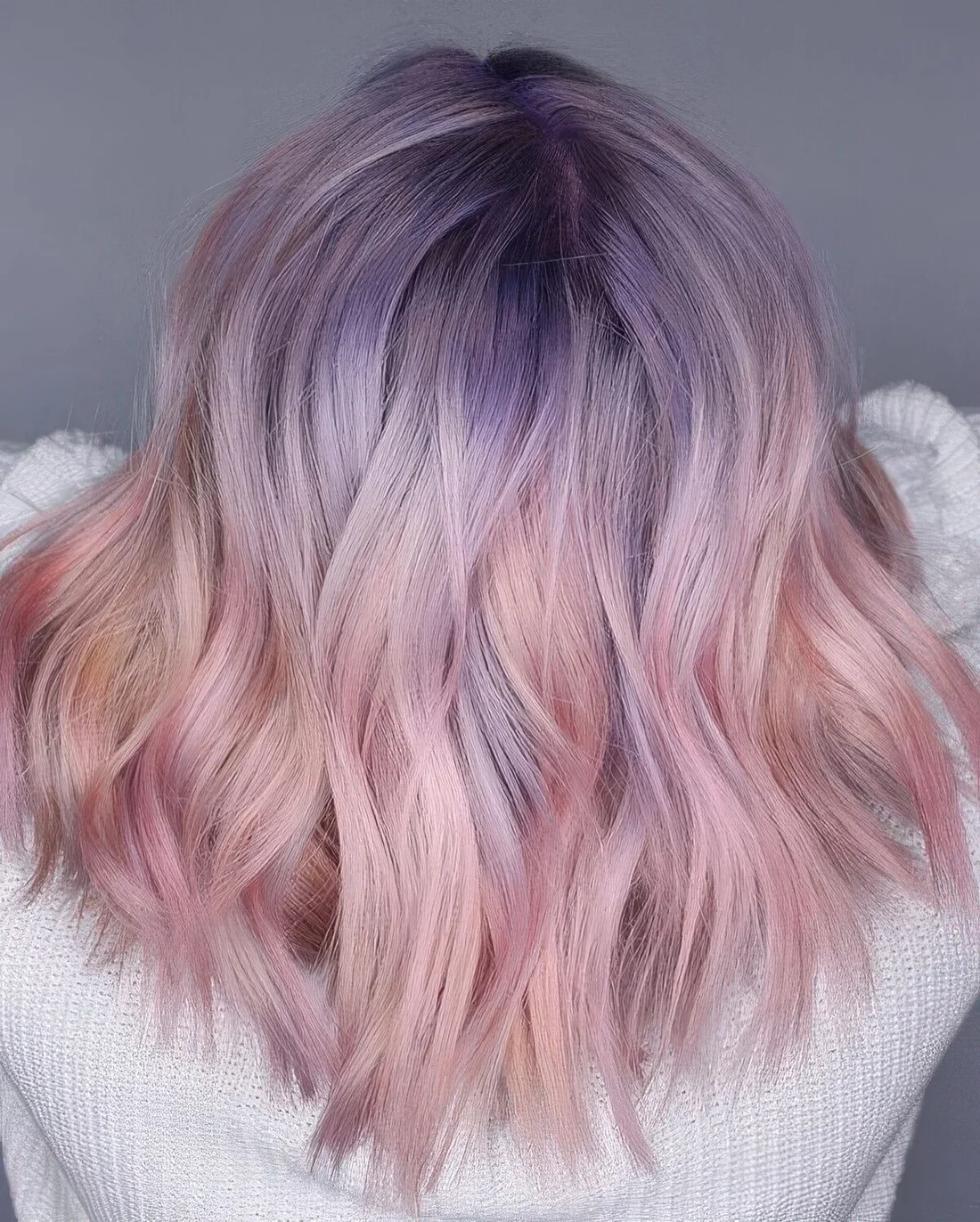 Medium-length pastel hair with purple root and pink ends.