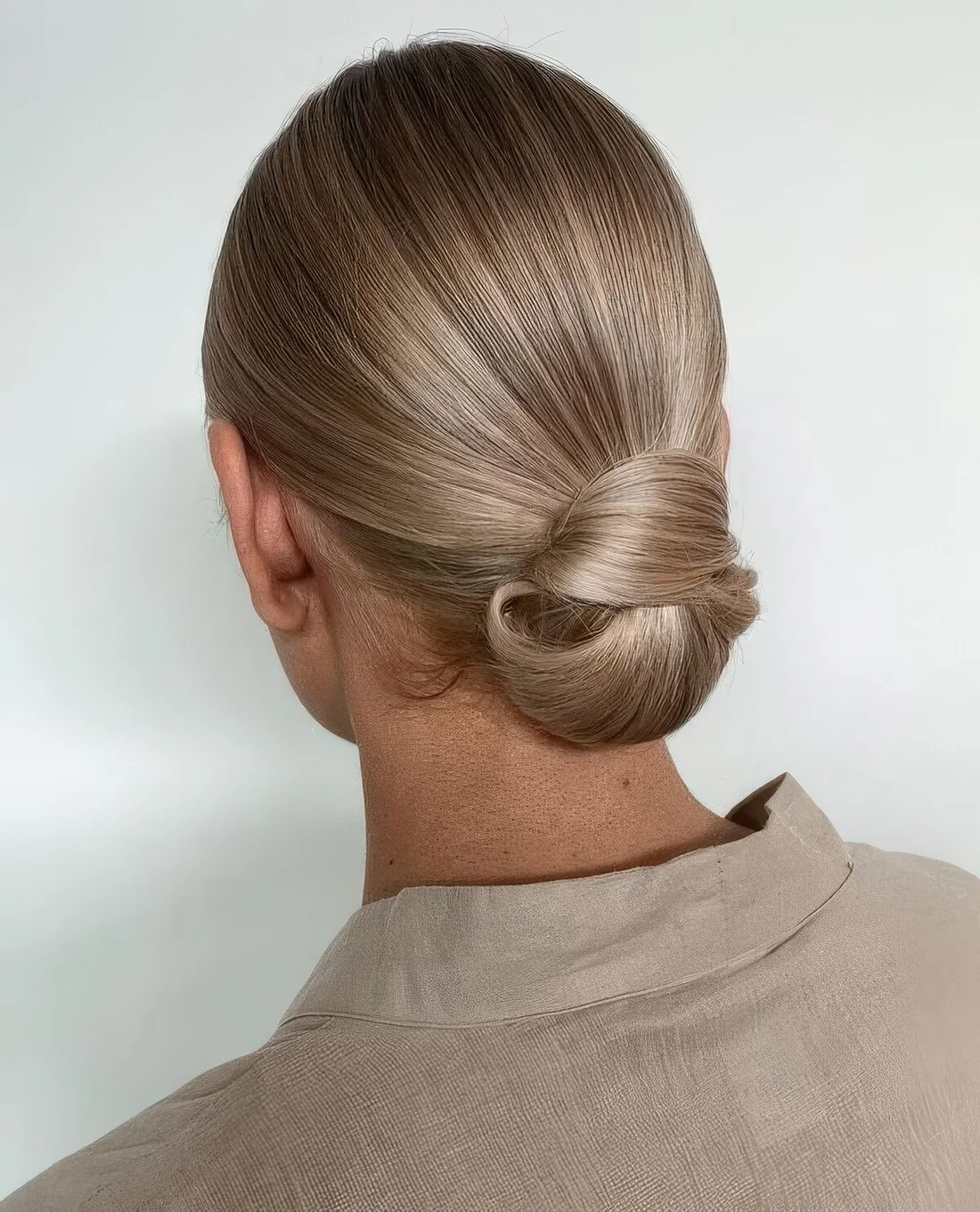 Photo showing sleek low knot with a sleek top, with the hairstyle clearly visible.