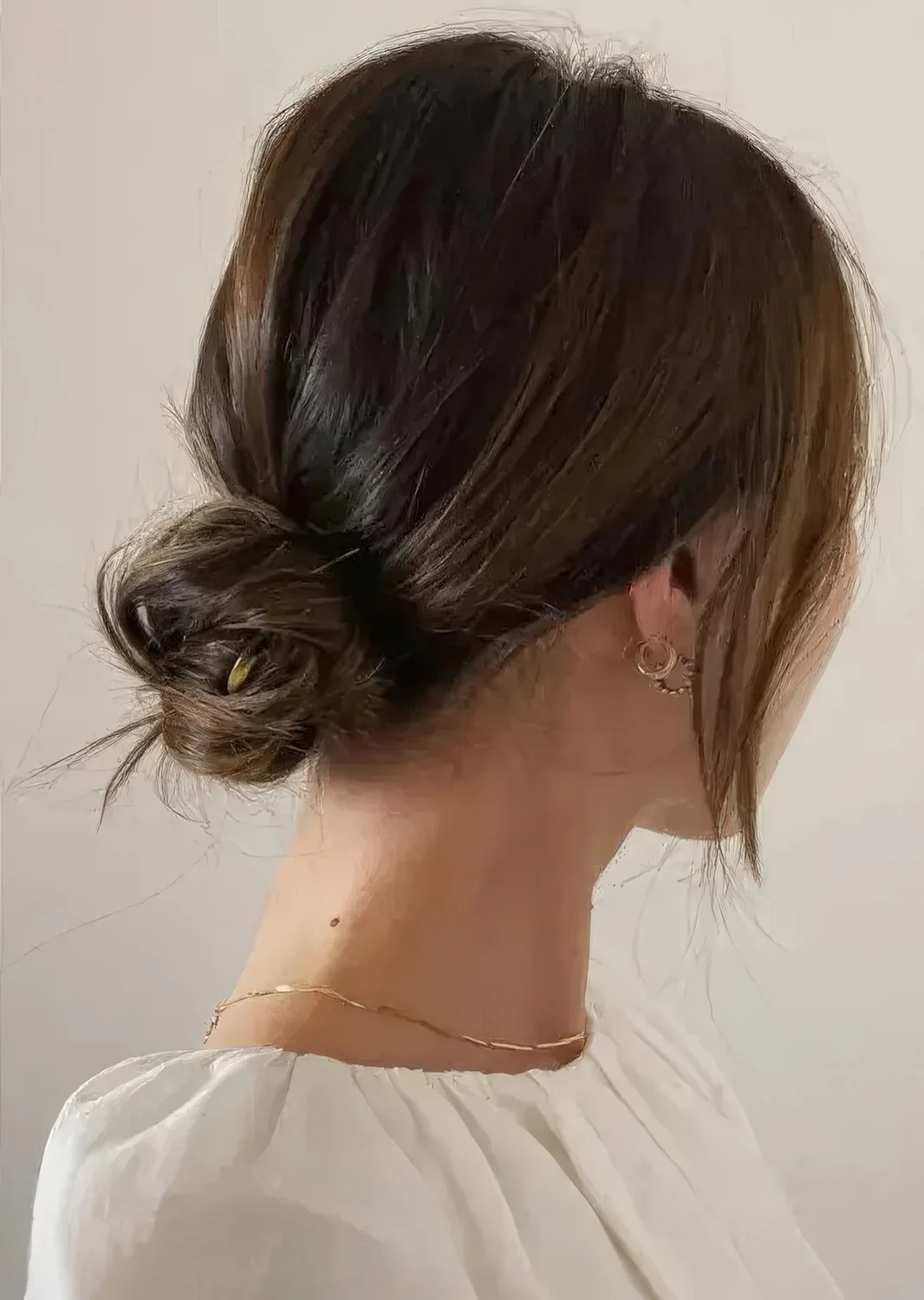 Chic and cool messy low bun with a bump on top and face-framing locks.