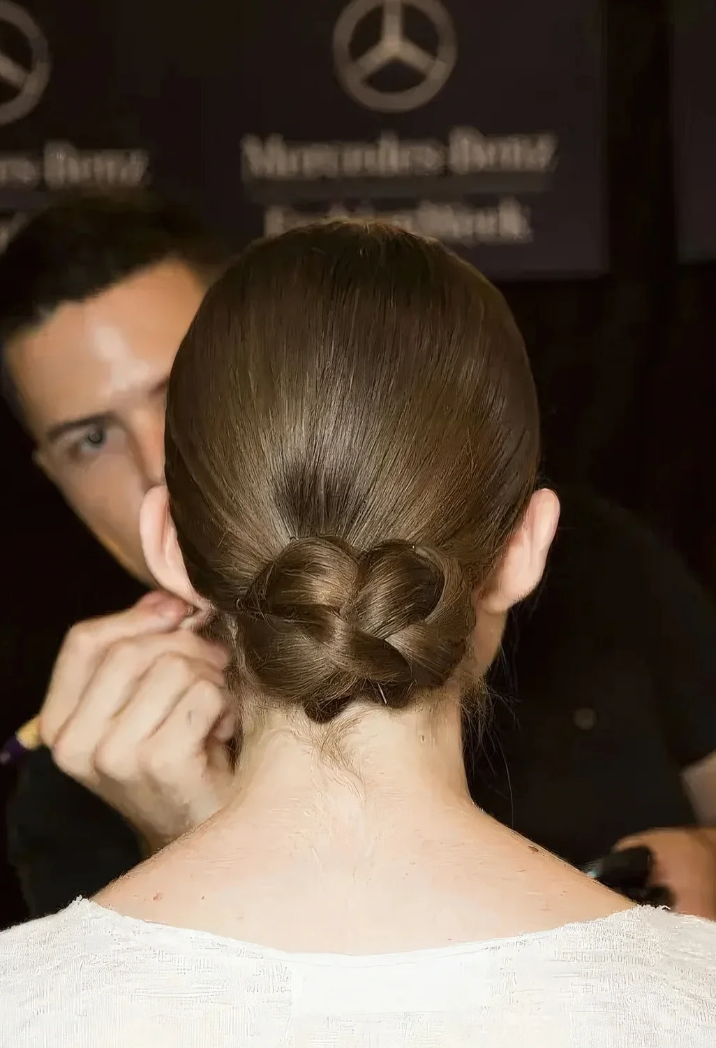 Photo showing sleek low updo with a braided bun, with the hairstyle clearly visible.