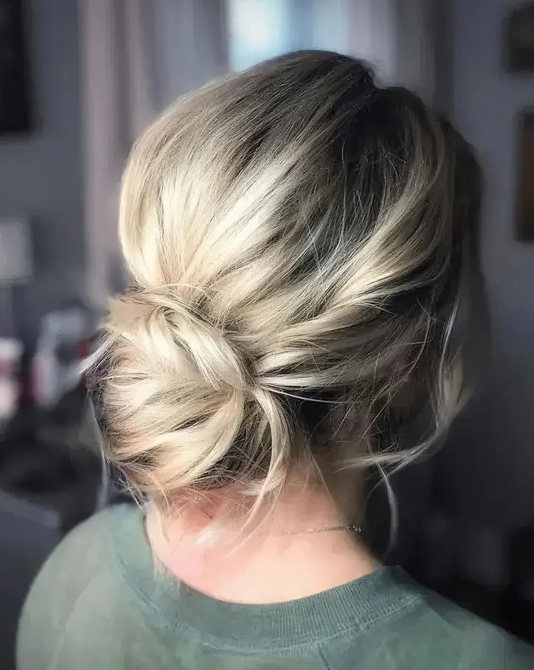 Simple and elegant low bun with a volume on top, some locks down.