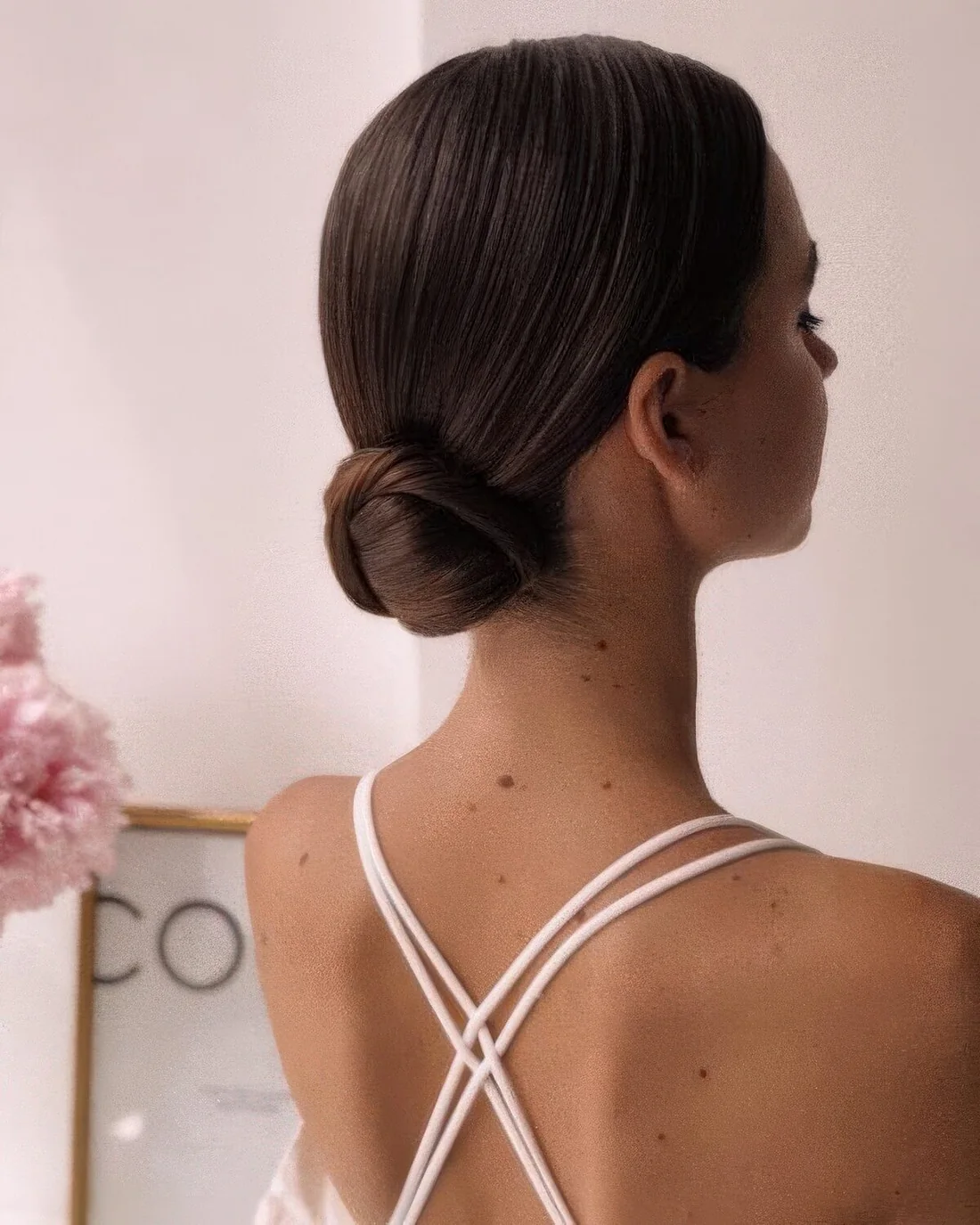 Minimalist sleek wrapped low bun and a sleek top.