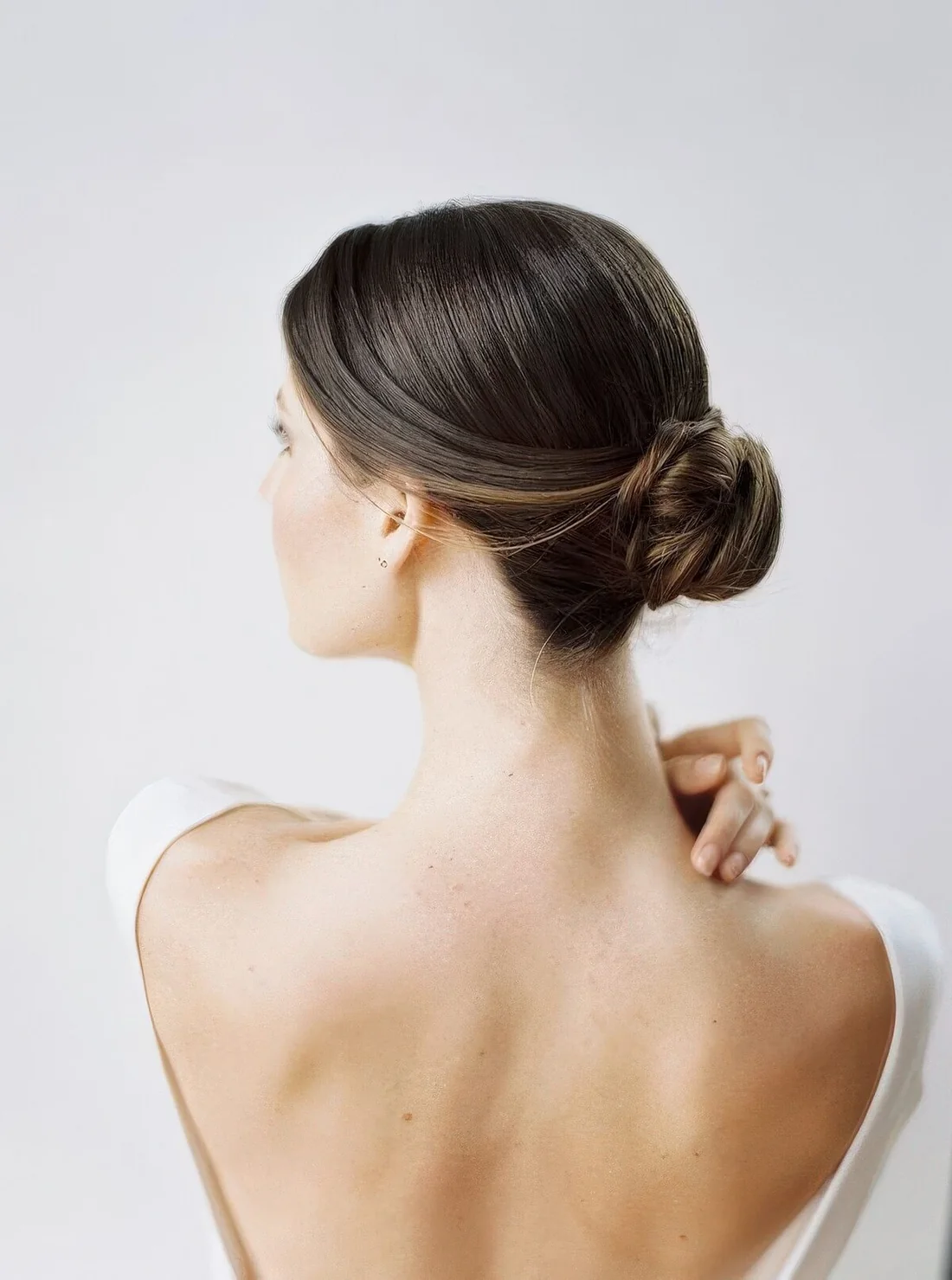 Photo showing twisted midi bun with a sleek top, with the hairstyle clearly visible.